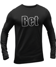 Load image into Gallery viewer, The design is the word Bet, written in black lettering with a white outline. Printed on a black long sleeve shirt by Bella+Canvas.