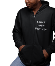 Load image into Gallery viewer, The design is the words &#39;check your privilege&#39; in white lettering. The design is printed on a black zip-up hoodie to the left of the zipper.