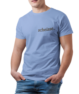 The design is the word scheisse. in brown lettering. The design is printed on the left side of the carolina blue tee.