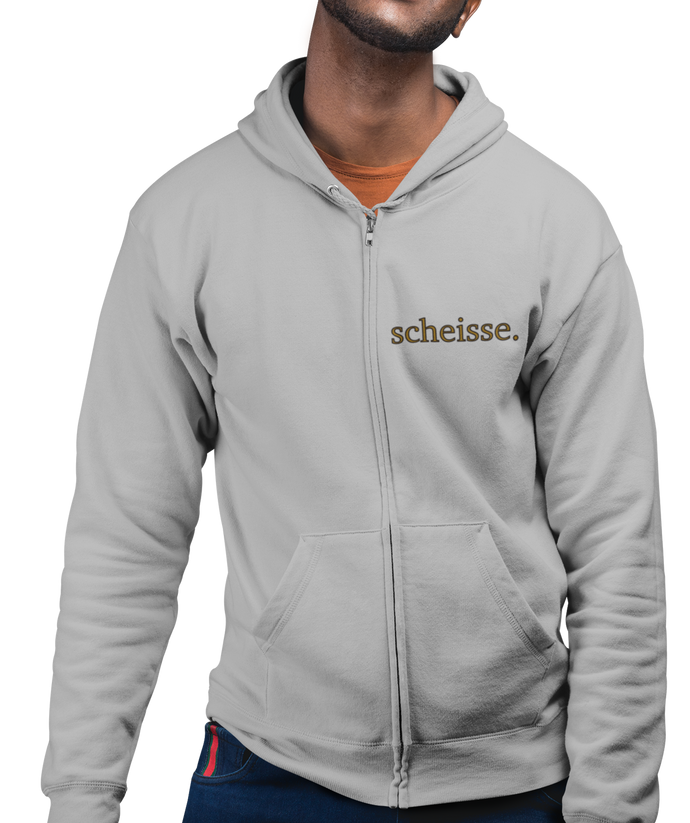 The design is the word scheisse. written in brown lettering. The design is on the left side of the zipper on this athletic grey hoodie.